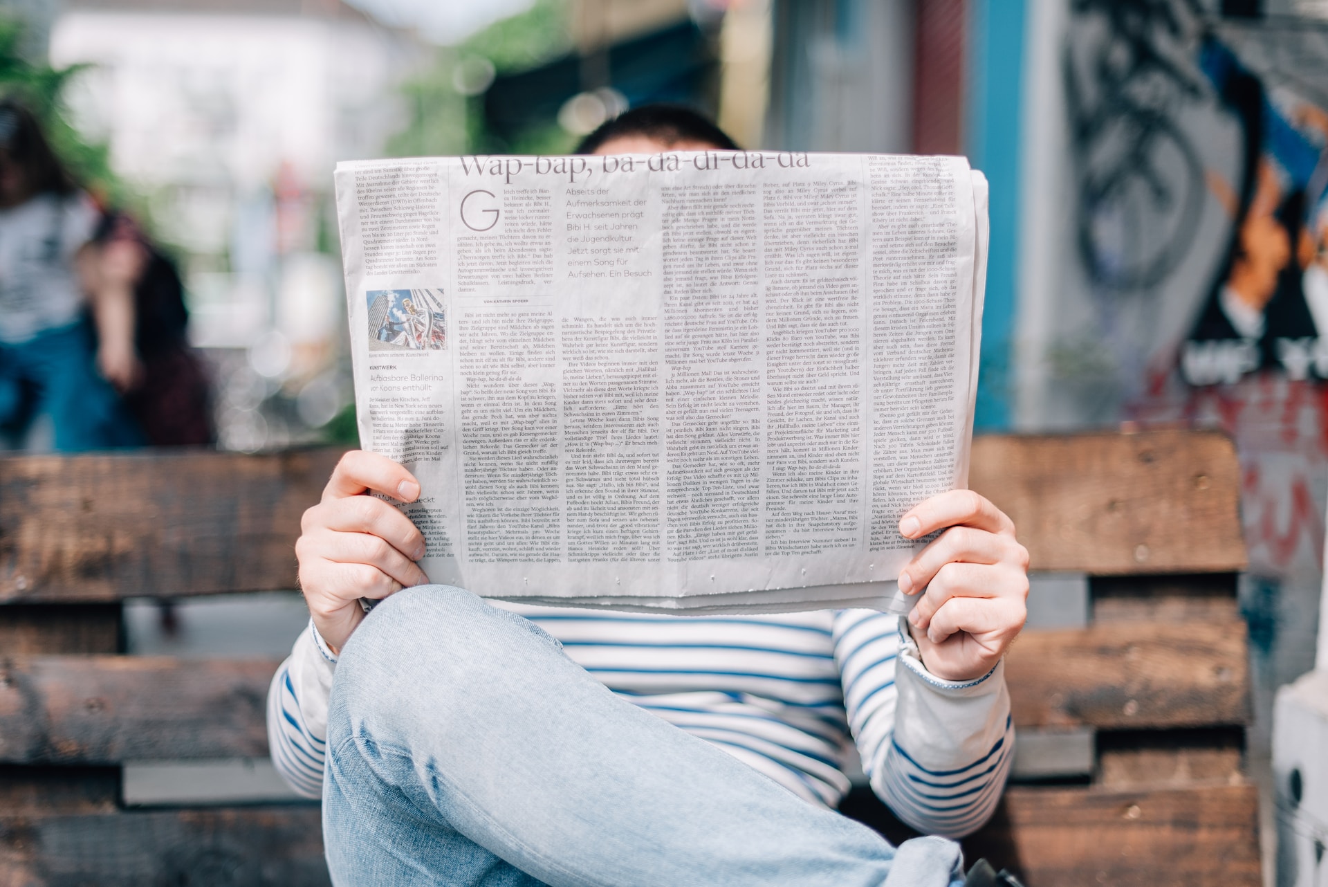 ベンチで新聞を読んでいる人