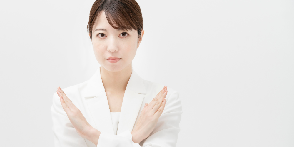 腕で罰と示している女性