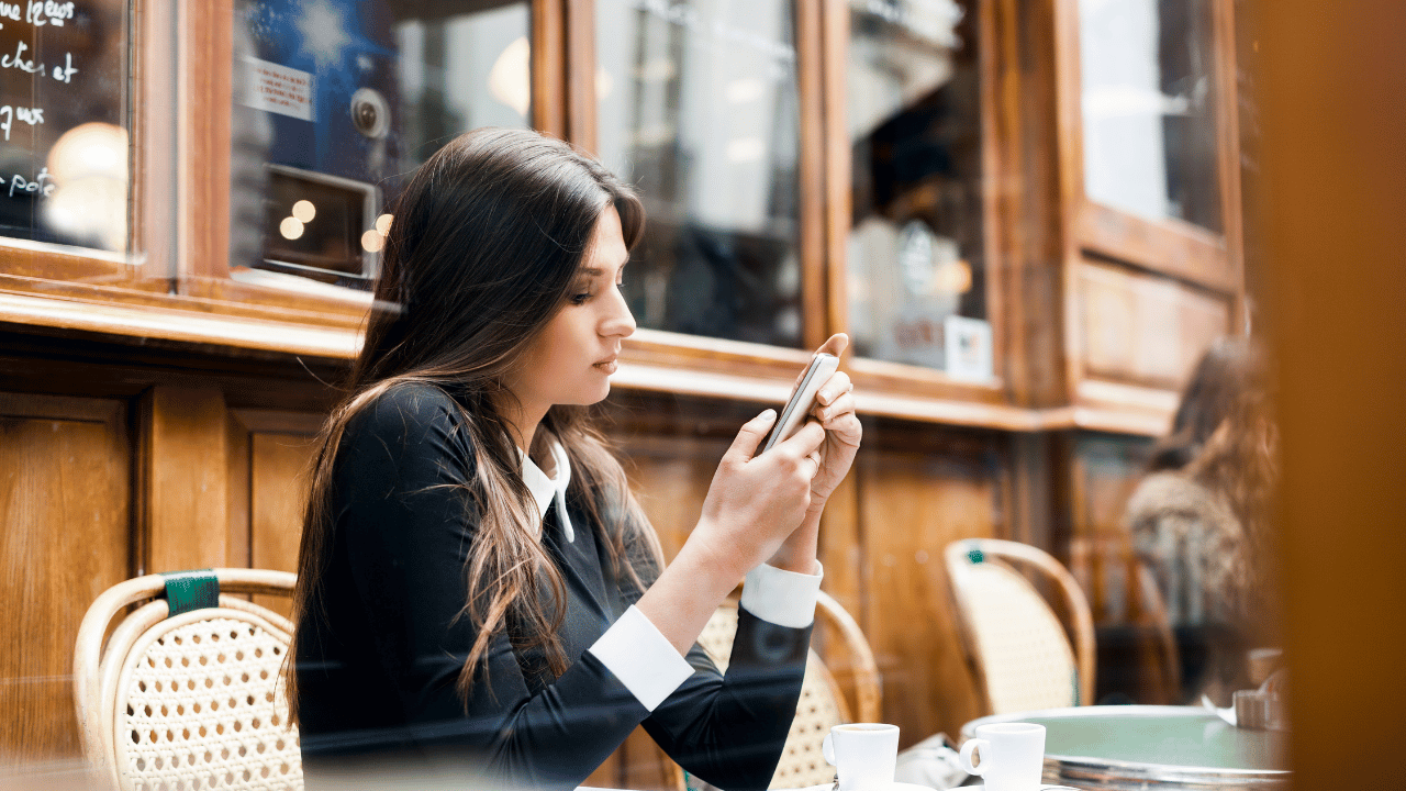 座ってスマホを見てる女性